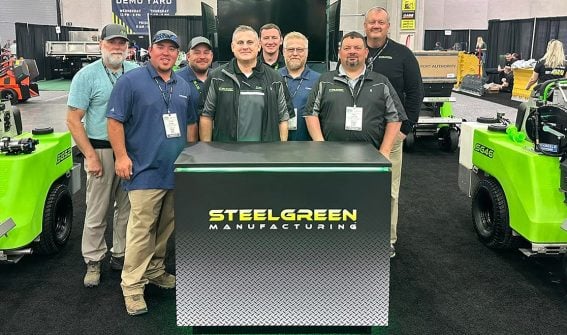 Steel Green employees smiling in front of equipment